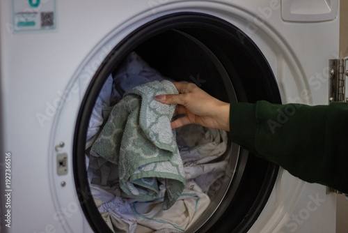 Wallpaper Mural Loading laundry into washing machine in self service laundromat close up Torontodigital.ca
