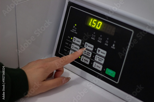 Wallpaper Mural Female hand selecting washing program on control panel close up Torontodigital.ca