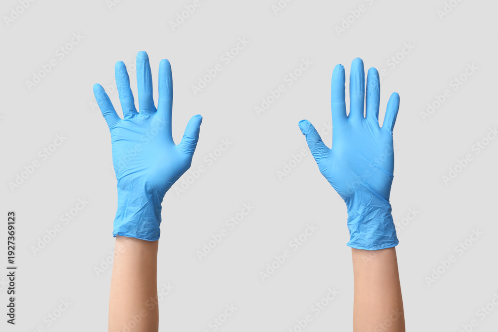 Obraz premium Female hands in medical gloves on grey background