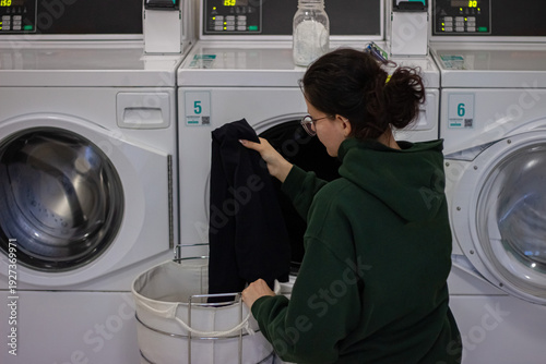 Wallpaper Mural Woman loading clothes into tumble dryer in self service laundromat Torontodigital.ca