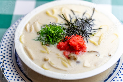 明太子、大葉、刻み海苔を添え、クリーミーな和風ホワイトソースにパスタを合わせた一皿。明太子のつぶつぶ感と薬味のアクセント、和洋折衷の優しい味わいを伝えるランチやディナーメニューの販促・広告用素材に。 | A Mentaiko (cod roe) and white sauce pasta topped with Shiso leaves and shredded Nori seaweed.