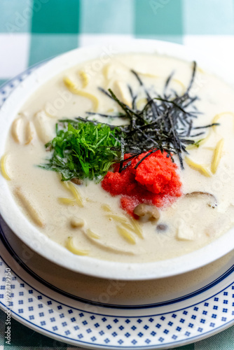 明太子、大葉、刻み海苔を添え、クリーミーな和風ホワイトソースにパスタを合わせた一皿。明太子のつぶつぶ感と薬味のアクセント、和洋折衷の優しい味わいを伝えるランチやディナーメニューの販促・広告用素材に。 | A Mentaiko (cod roe) and white sauce pasta topped with Shiso leaves and shredded Nori seaweed.