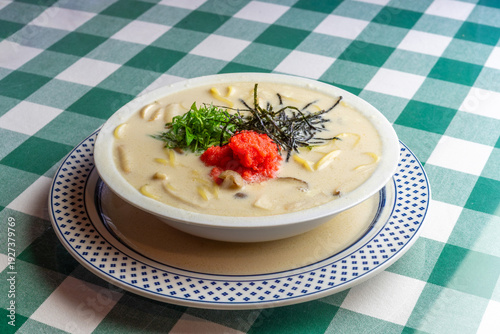 明太子、大葉、刻み海苔を添え、クリーミーな和風ホワイトソースにパスタを合わせた一皿。明太子のつぶつぶ感と薬味のアクセント、和洋折衷の優しい味わいを伝えるランチやディナーメニューの販促・広告用素材に。 | A Mentaiko (cod roe) and white sauce pasta topped with Shiso leaves and shredded Nori seaweed.