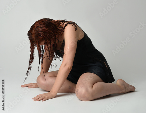Konstfotografi full length portrait of beautiful female model with wet messy hair and simple black silk robe gown, bruised legs