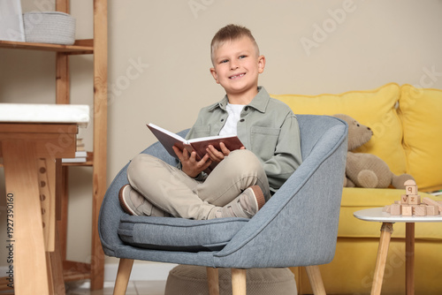 Cute little boy reading boo...