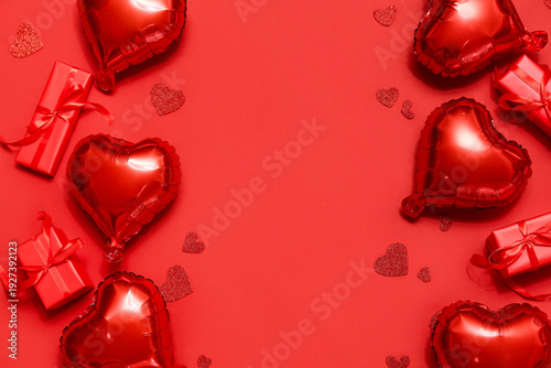 Air balloons in shape of heart and gift boxes on red background. Valentine's day celebration