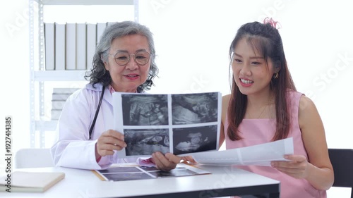 Female doctor explains the results of a prenatal checkup for an Asian woman. Health concept. Self-care during pregnancy.