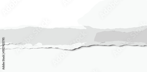 Torn paper edge revealing a gray landscape view from a close-up perspective