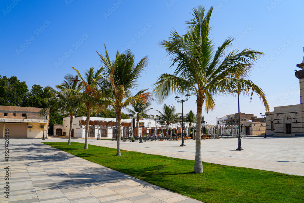 Fototapeta premium Modern landscaped plaza with palm trees in the historic district of Yanbu, Saudi Arabia