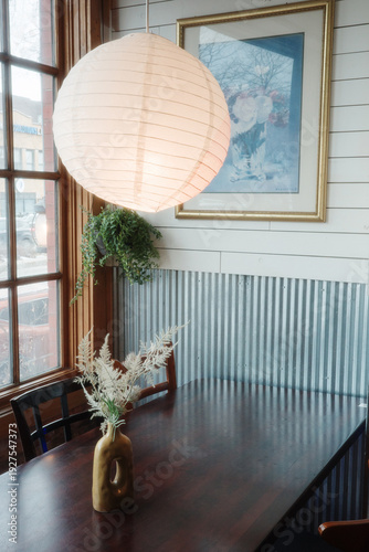 Cozy Dining Nook With Paper Lantern, Wooden Table, Vase Arrangement and Indoor Plant by Window