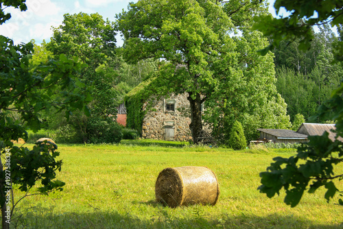 Rustic Stone House in a Green Countryside with Hay Bale
