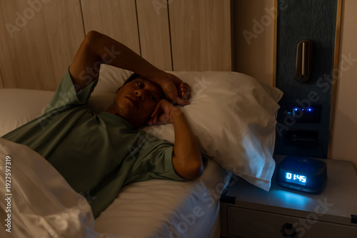 Fotografija man in bed late trying to sleep suffering insomnia, sleepless or scared in a nightmare, looking sad worried and stressed