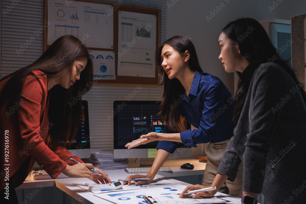 Fototapeta premium Women team analyzing data charts late at night working overtime