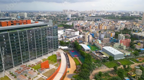 Aerial view of a modern glass office building and electronic plant with solar panels in Electronic city, Bengaluru, India