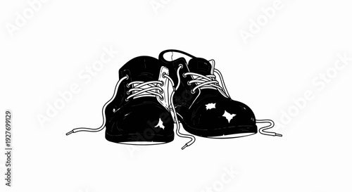 A pair of black leather ankle boots with white laces, sitting on a white background