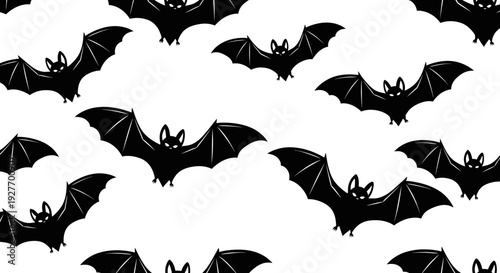 A seamless pattern of black bat silhouettes with outstretched wings against a white background, evoking a Halloween theme.