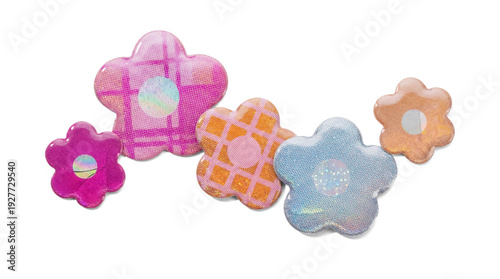 Foto assortment of iridescent holographic flower stickers with patterned surfaces, isolated against a dark background
