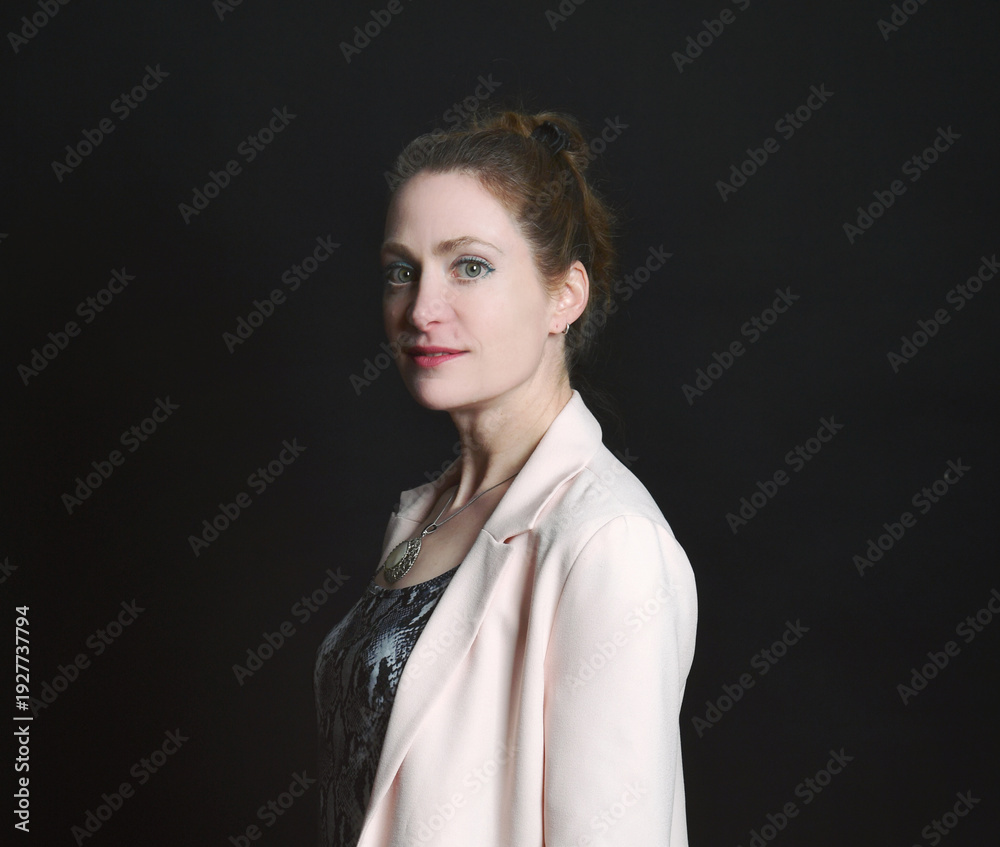 Obraz premium Low-Key-Portrait eines Models im Mantel vor dunklem Hintergrund. Dramatisches Licht, starke Schatten und roter Lippenstift setzen elegante, ausdrucksstarke Akzente.