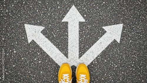A person standing on a road with three white arrows pointing in different directions, wearing yellow shoes and standing at a crossroads, viewed from directly above at a decision point