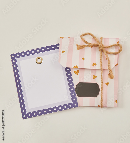 Beautiful floral arrangements: a hand-held bouquet of orange and white roses, and a pink tulip arrangement in a decorative striped box against a white brick wall.