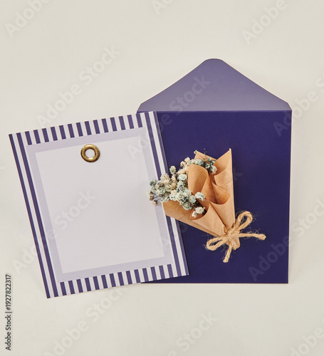 Beautiful floral arrangements: a hand-held bouquet of orange and white roses, and a pink tulip arrangement in a decorative striped box against a white brick wall.