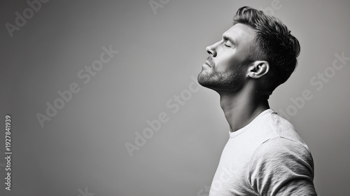 Black and white side profile portrait of a handsome young man with closed eyes and styled hair.