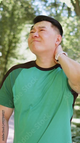 Sport Asian jogger man have shoulder pain, injury concept. Fitness muscular Japanese male has neck pain and shoulders after running having an ache in his arm. Athlete runner pain in joints outdoors.