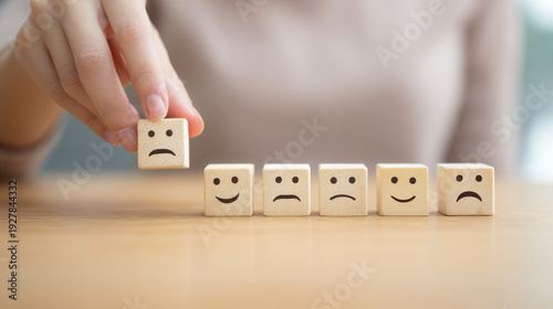 woman changes expression cube from unhappy to happy. happy expression selected. Customer service assessment and technology customer support concept