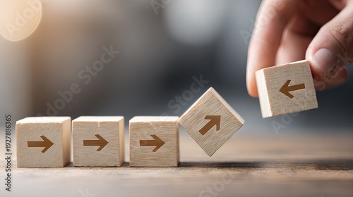 Human hand places a wooden block with a left arrow next to blocks showing a right arrow, symbolizing change in direction