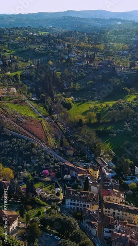 4K aerial vertical video of Tuscan countryside near Florence. Aerial view of rolling green hills, villas, and cypress trees. Vertical video for Italy travel reels.