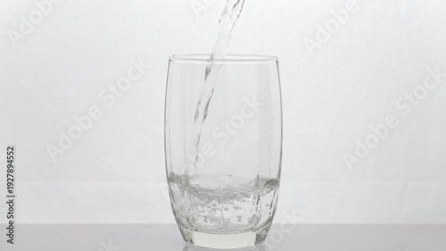 Slow-motion video of clean water being poured into a glass on white background healthy drink.	