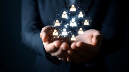Businessman holds glowing white human resource icons in hands during a meeting about team management at an office
