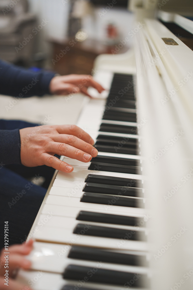 Obraz premium Hands playing piano keys in a indoor setting during daytime