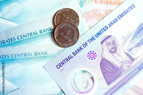 Close-up of United Arab Emirates Currency: AED Banknotes and Dirham Coins Scattered on Surface
