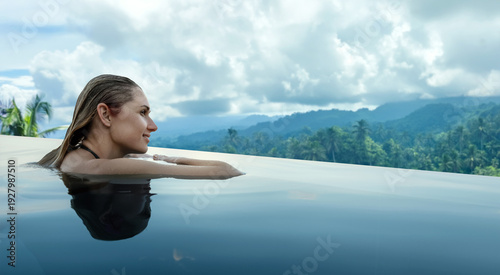 woman relaxing and enjoying view to the tropical jungle from infinity pool. copy space
