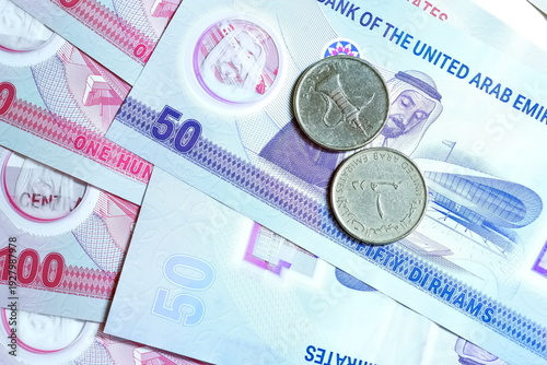 Close-up of United Arab Emirates Currency: AED Banknotes and Dirham Coins Scattered on Surface