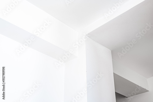 Wallpaper Mural Interior corner of a modern room featuring white walls and ceiling with sharp angles, showcasing minimalist architectural design and clean lines in a bright setting Torontodigital.ca