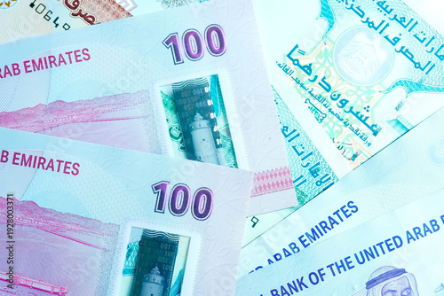 Close-up of United Arab Emirates Currency: AED Banknotes and Dirham Coins Scattered on Surface