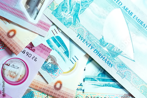 Close-up of United Arab Emirates Currency: AED Banknotes and Dirham Coins Scattered on Surface