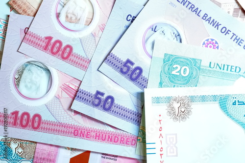 Close-up of United Arab Emirates Currency: AED Banknotes and Dirham Coins Scattered on Surface