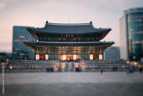 Traditional palace building stands against a modern city skyline at dusk.