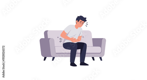 A young man with dark hair, wearing a white t-shirt and dark pants, sits hunched on a light gray sofa, clutching his stomach in pain against a white background.