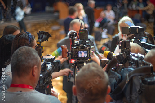 Crowded Press Conference with Video Cameras and Microphones for Breaking News Concept