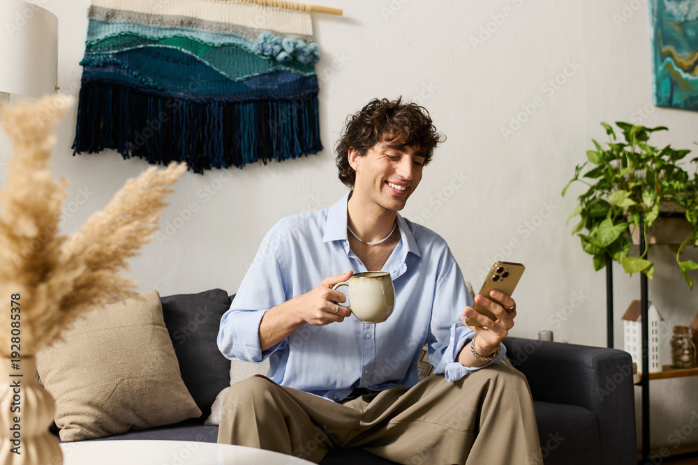 © Bliss - Stylish young man enjoying coffee while checking his phone in a chic modern apartment © Bliss - Stylish young man enjoying coffee while checking his phone in a chic modern apartment