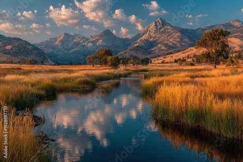 A peaceful wetland with reeds, clear reflections, and distant mountains under a golden sky