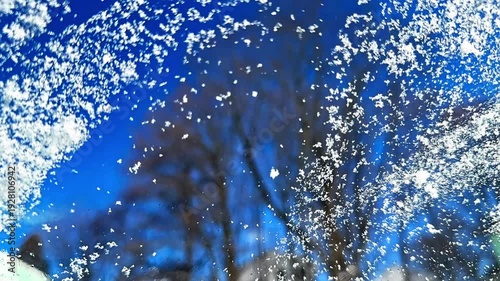 Time lapse frozen ice being scraped off a car windshield with an ice scraper on a sunny winter morning. Morning routine before driving in cold weather
