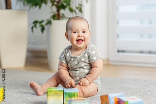 Smiling Baby Sitting and Playing at Home. Baby care