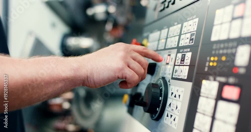 Technician hand operating control panel of industrial CNC machine in factory
