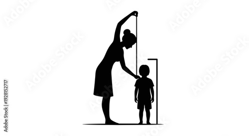 Mother measuring child's height against wall at home.