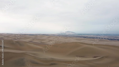Aerial view drone Extraordinary dessert right behind the Oasis city in Huacachina, Ica, Peru cloudy day 4k.